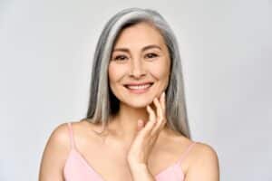 A woman smiling and showing the results of ALASTIN Skincare® in San Antonio