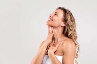 A woman touching her neck and chin after KYBELLA in San Antonio