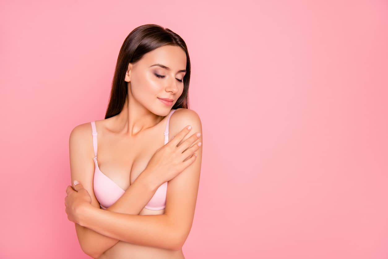 Woman posing in white bra after seeing a plastic surgeon serving Boerne
